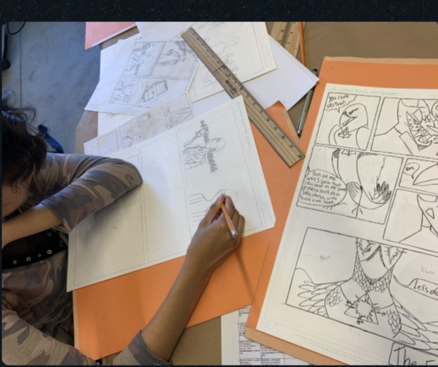 Student sketching comic pages
